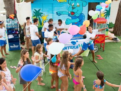 Des enfants célèbrent avec des ballons et des jeux lors d'un événement en plein air à l'hôtel.