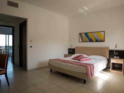 Chambre d'hôtel moderne avec lit double, tables de nuit et vue sur le balcon