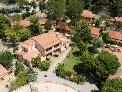 Aerial view of a resort with multiple buildings and abundant trees.