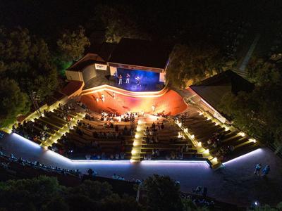 Vue aérienne nocturne d'un hôtel éclairé avec piscine et parkings
