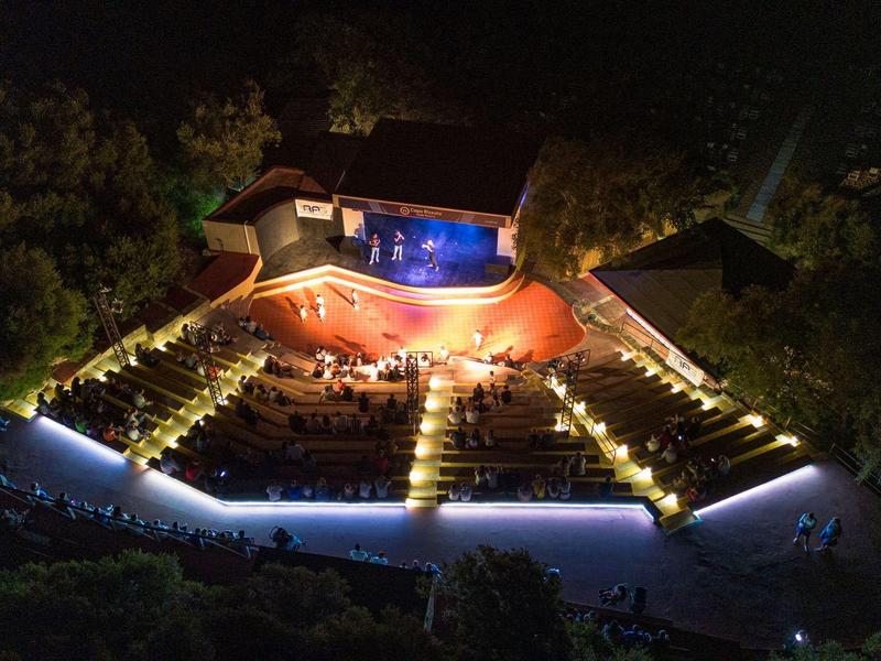 Vue aérienne nocturne d'un hôtel éclairé avec piscine et parkings
