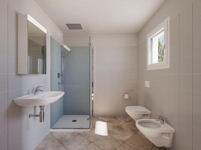 Salle de bain lumineuse avec douche, lavabo, toilettes et bidet dans un style moderne.