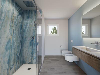 Salle de bain moderne avec mur bleu, douche en verre, WC suspendu et double lavabo.