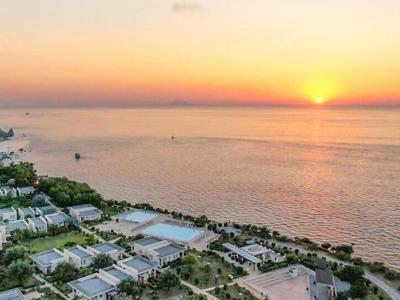 Coucher de soleil sur la côte avec un complexe et une mer calme bleue