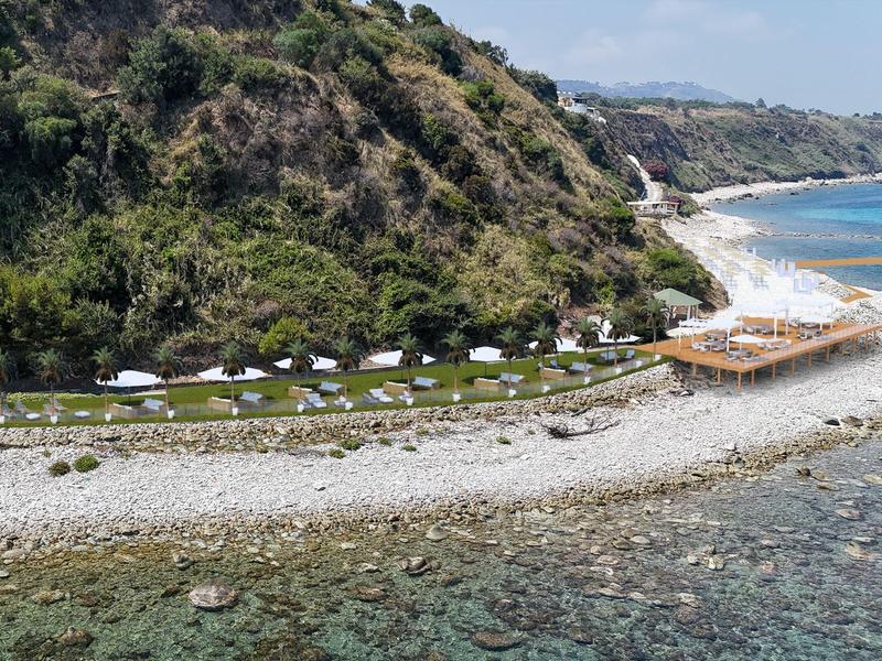 Station balnéaire avec tentes près de l'eau claire sous des collines boisées.