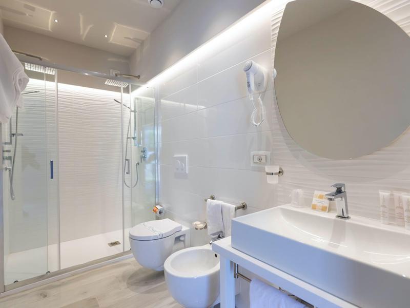 Moderne badkamer met douche, toilet en wastafel in heldere witte tinten.