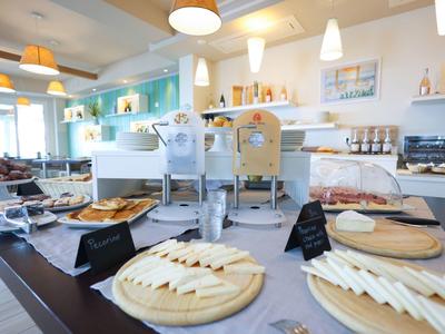 Hotel breakfast buffet with various cheese and bread options on wooden platters.