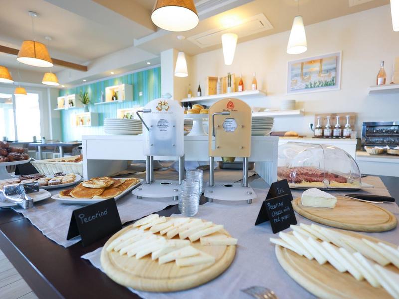 Hotel breakfast buffet with various cheese and bread options on wooden platters.