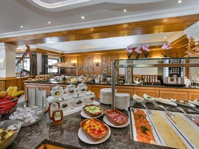 Buffet mit verschiedenen kalten und warmen Speisen in einem gemütlichen, holzverkleideten Speisesaal.