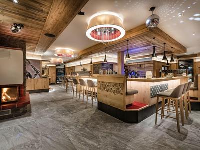Gemütliche Hotelbar mit Holzdecke, Kamin und moderner Beleuchtung