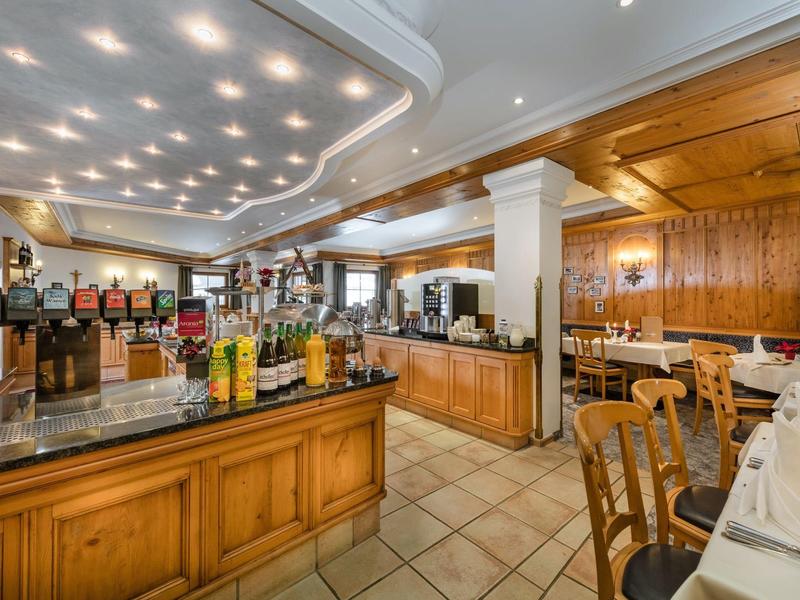 Gemütliches Restaurant mit Holztheke, gedeckten Tischen und warmem Deckenlicht.