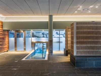 Modernes Hallenbad mit Holzverkleidungen und stilvoller Beleuchtung in einem Hotel.