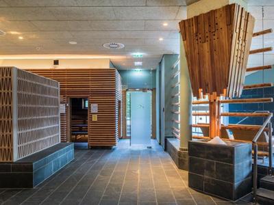 Moderner Eingangsbereich mit Holzverkleidung, Sitzbank und dekorativem Holzkunstwerk.