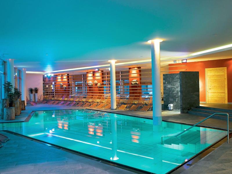 Moderner Innenpool mit Beleuchtung und Liegebereichen in einem Hotel