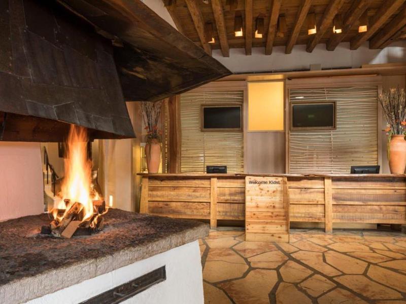 Gemütlicher Hotel-Loungebereich mit offenem Kamin und rustikalem Interieur.