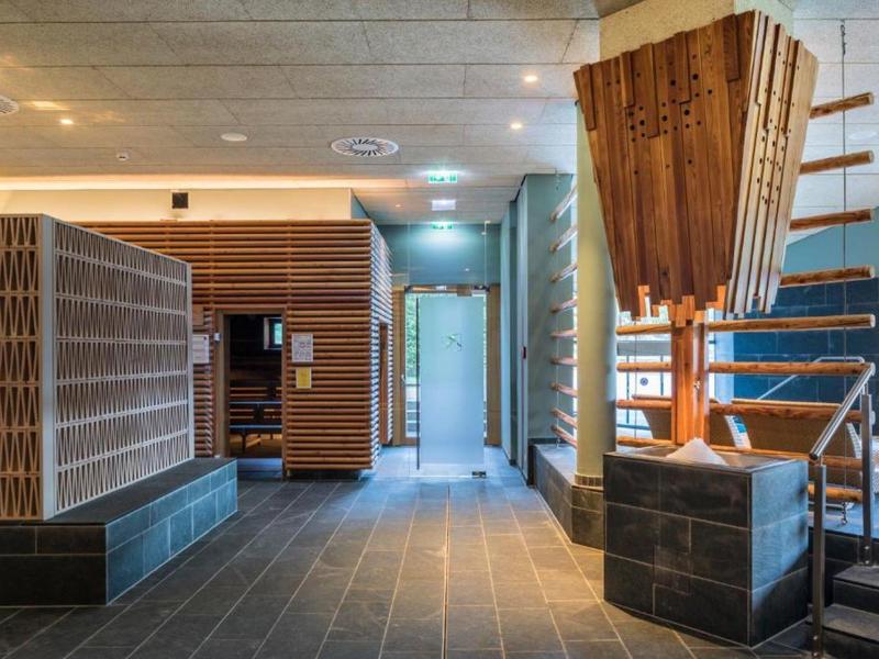 Moderner Eingangsbereich mit Holzverkleidung, Sitzbank und dekorativem Holzkunstwerk.