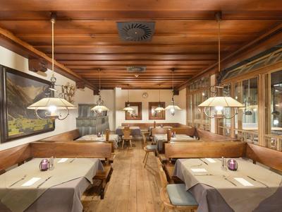 Gemütliches Restaurant mit Holzbänken, Holztischen und warmem Holzdekor.