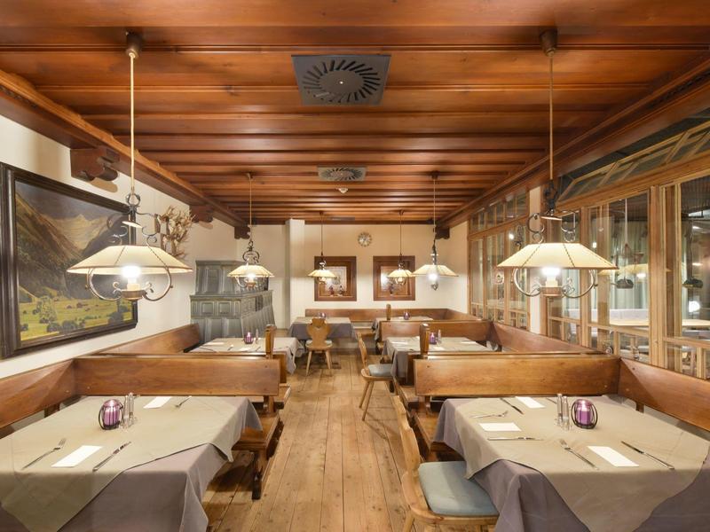 Gemütliches Restaurant mit Holzbänken, Holztischen und warmem Holzdekor.