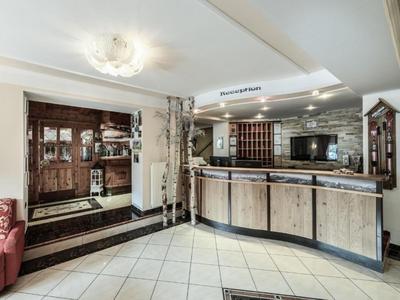 Moderne Hotelrezeption mit hellem Holzmöbeln und Empfangstresen in einem hellen Raum.