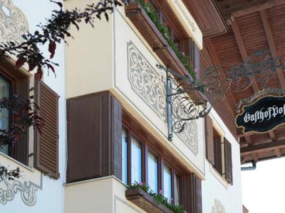 Außenwand eines Gebäudes mit dekorativen Elementen und einem Schild mit der Aufschrift "Gasthof".