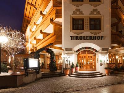 Ingresso dell'hotel illuminato con facciata in legno e finestre decorative di notte.