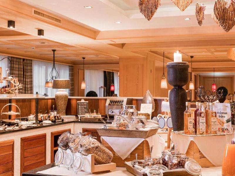 Gemütliches Holzinterieur mit Buffet, Schokoladenbrunnen und dekorativen Leuchten im Restaurant.