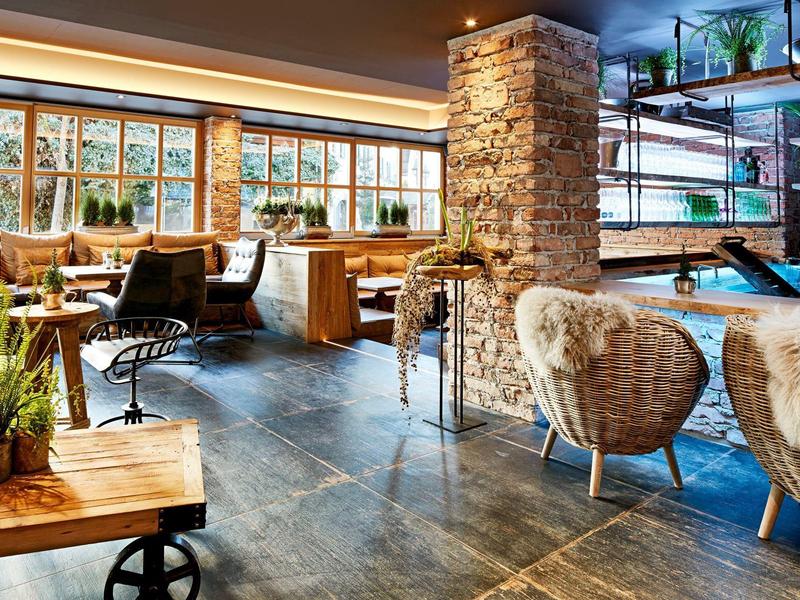 Espace lounge d'hôtel confortable avec sièges et plantes.