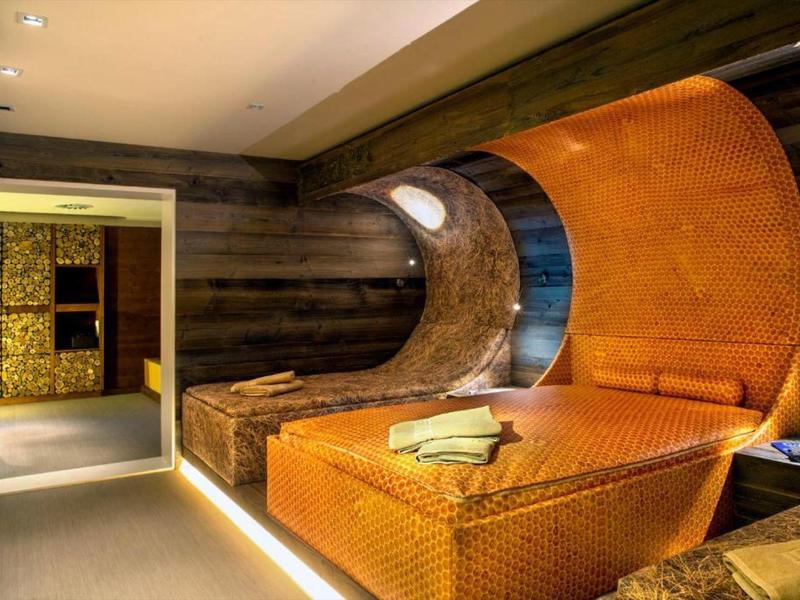 Salle de détente moderne avec sièges et espaces de repos courbés et rembourrés aux tons chauds.