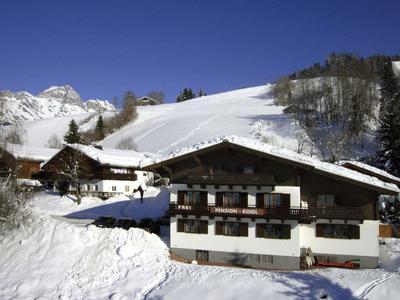 Snow-covered mountain lodges under a clear blue sky in a winter landscape