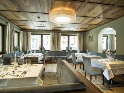 Elegant restaurant with set tables and wooden ceiling in a hotel.