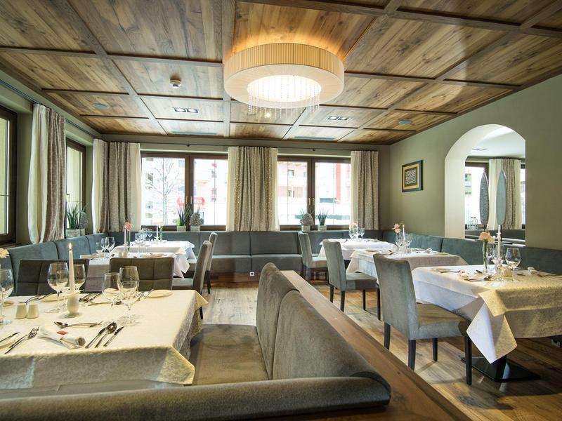 Jasna, elegancka restauracja z nakrytymi stołami i drewnianym sufitem w hotelu.