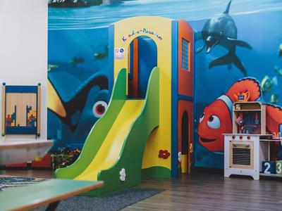 Barevné vnitřní hřiště se skluzavkou před stěnou hotelu s podvodním motivem