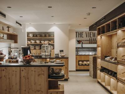 Moderne hotel lobby met houten planken, koffiemachine en stijlvolle verlichting.