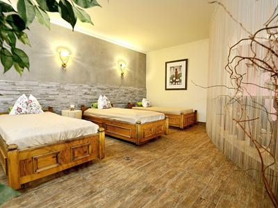 Camera d'hotel accogliente con due letti e pavimento in legno caldo.