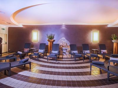 Gemütlicher Ruheraum mit gepolsterten Liegen, warmem Licht und Pflanzen für Entspannung.