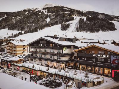 Paesaggio montano innevato con hotel e auto davanti in inverno.
