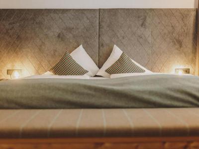 Letto matrimoniale accogliente con cuscini e coperta morbida in una camera d'hotel moderna.