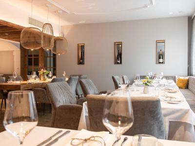 Elegantní restaurace s prostřenými stoly, pohodlnými židlemi a moderním osvětlením.