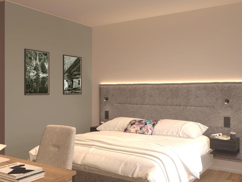 Modernes Schlafzimmer mit großem Bett, Kopfteile mit Beleuchtung und Stuhl am Schreibtisch.