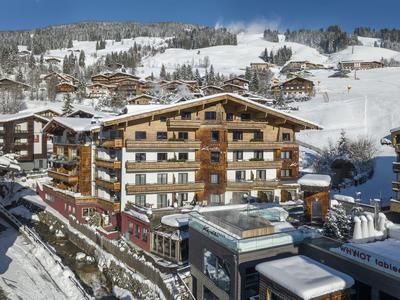 Drewniane chaty i budynki w ośnieżonym górskim kurorcie pod czystym niebieskim niebem