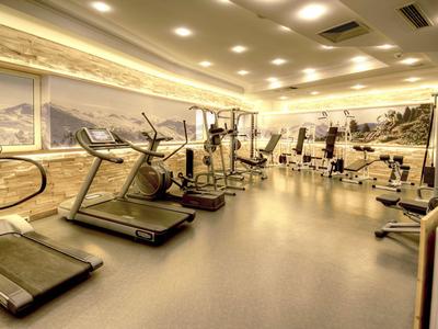 Modern ausgestatteter Fitnessraum mit Laufbändern und Trainingsgeräten in einem Hotel.