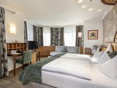 Nowoczesny pokój hotelowy z dużym łóżkiem, biurkiem i miejscem do siedzenia przy oknie