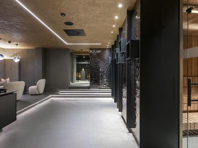 Nowoczesny korytarz hotelowy z miękkim oświetleniem i minimalistycznymi miejscami do siedzenia.