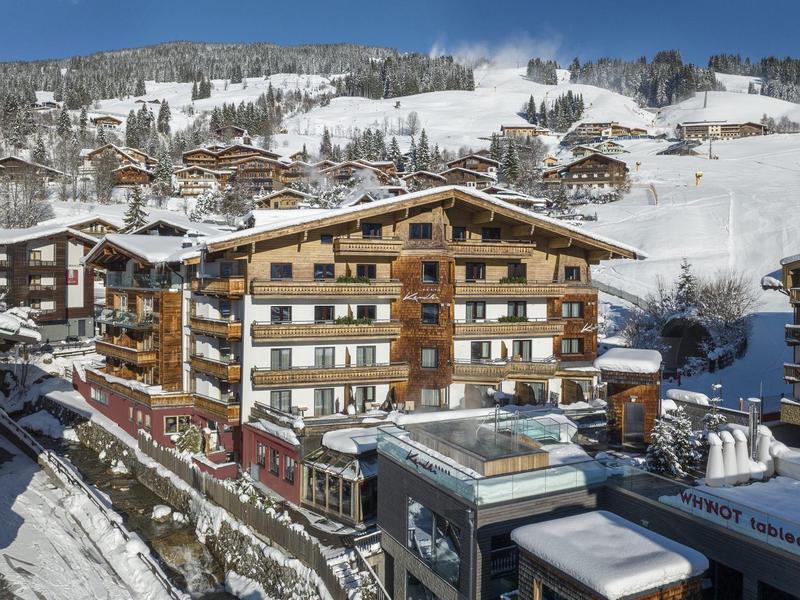 Drewniane chaty i budynki w ośnieżonym górskim kurorcie pod czystym niebieskim niebem