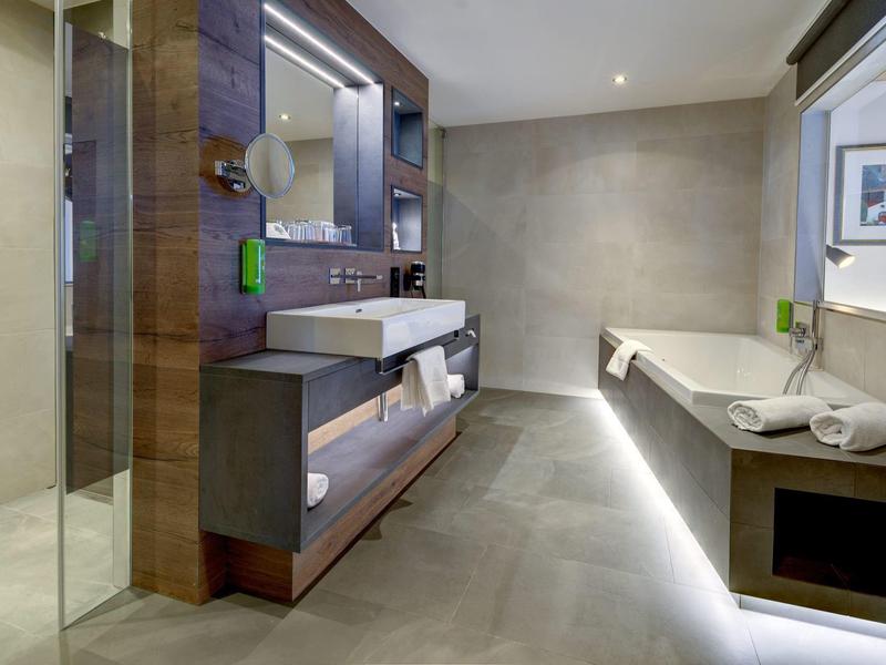 Nowoczesna łazienka z prysznicem, dużą umywalką i wanną w neutralnych kolorach.