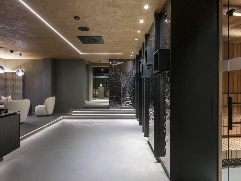 Nowoczesny korytarz hotelowy z miękkim oświetleniem i minimalistycznymi miejscami do siedzenia.