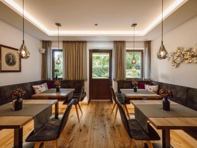 Nowoczesna jadalnia z drewnianą podłogą, wiszącymi lampami i dekoracjami ściennymi.