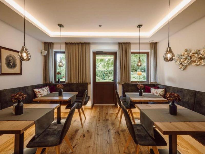 Nowoczesna jadalnia z drewnianą podłogą, wiszącymi lampami i dekoracjami ściennymi.