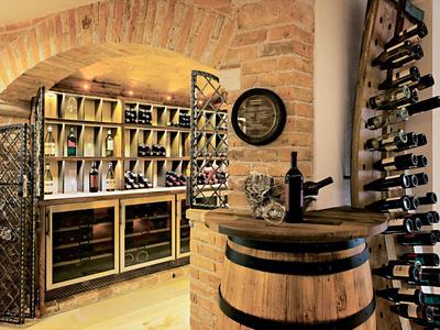 Rustic wine cellar with barrels, wine racks, and warm lighting in a stone vault.