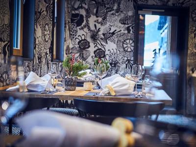 Elegant restaurant with artistically designed walls and set dining tables.